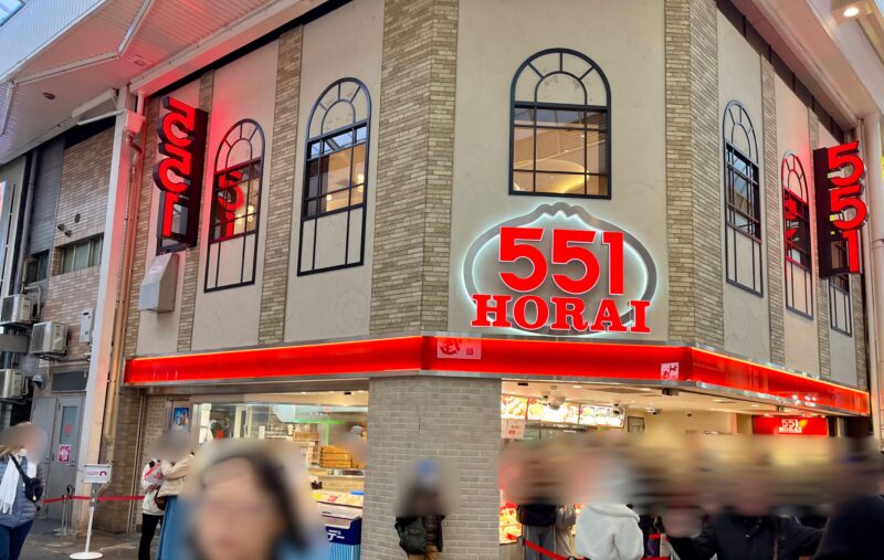 大きな赤い看板が目印の551HORAI本店の外観。なんばの商店街の一角にあり、行列ができる人気店。