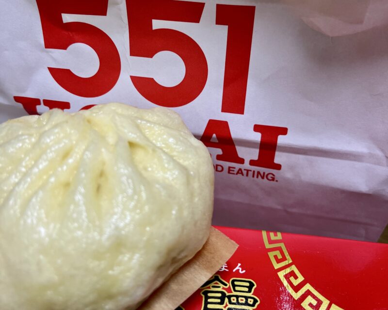 551蓬莱の豚まんのアップ。背景に551の紙袋と赤い箱が写っている