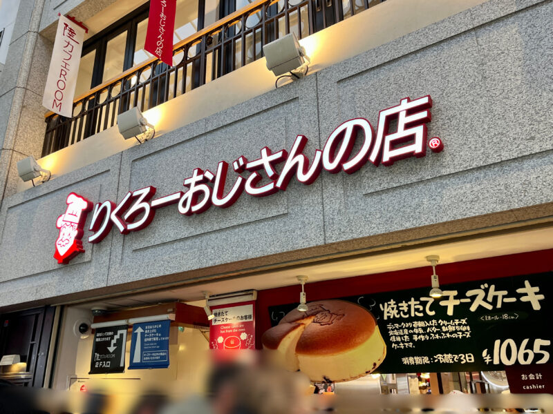 大阪なんばにあるりくろーおじさんの店の外観と、焼きたてチーズケーキを買い求める人の行列