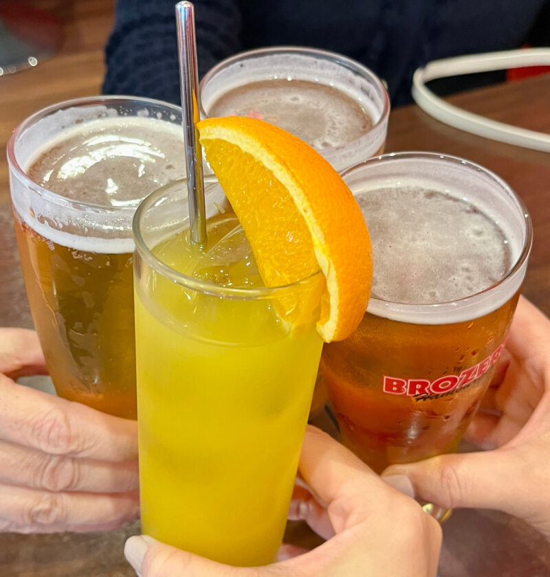 乾杯しているドリンク4杯（ビール3杯＋オレンジのカクテル1杯）のアップ。